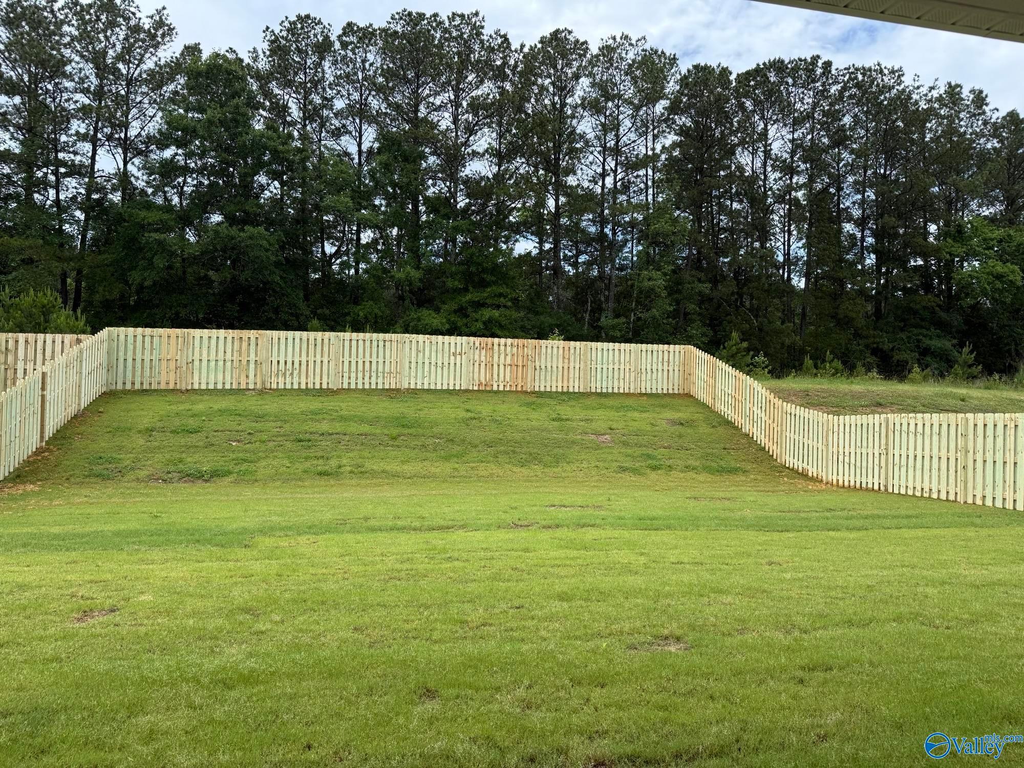 Spacious, fenced-in backyard with lush green lawn at The Rockford B home in Cain Park, Hartselle, Alabama.