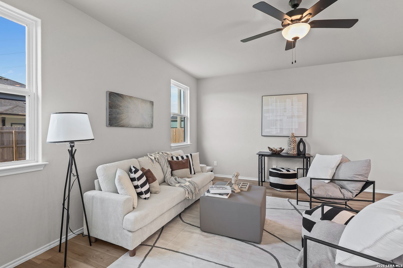 Modern living room with neutral decor and ceiling fan in The Daphne H floor plan by Davidson Homes in Seguin, Texas.