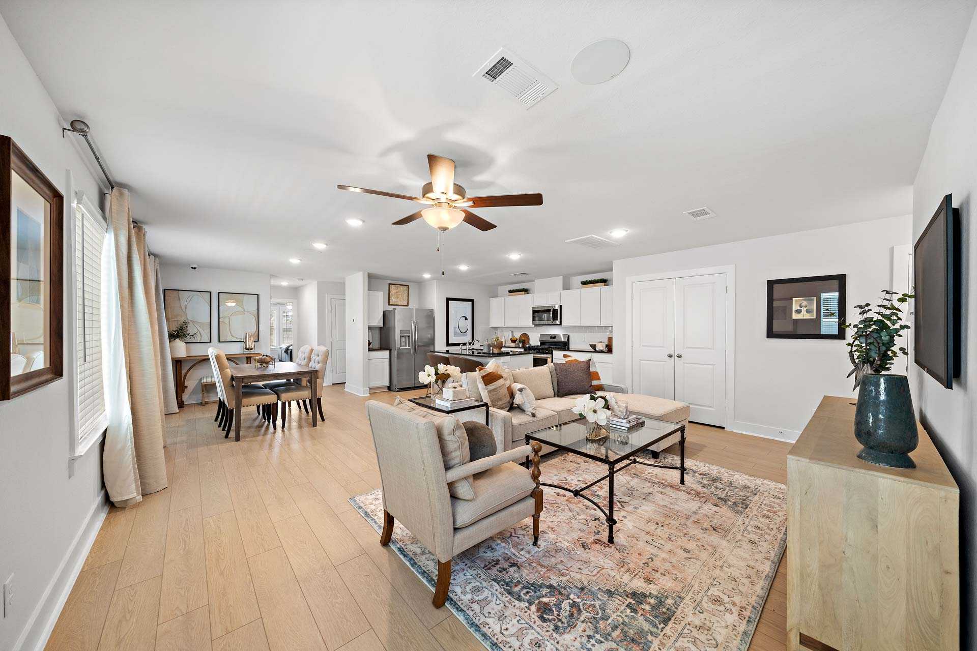Spacious open-concept living and kitchen at Haven at Kieth Harrow in Cypress Texas with hardwood floors and neutral decor