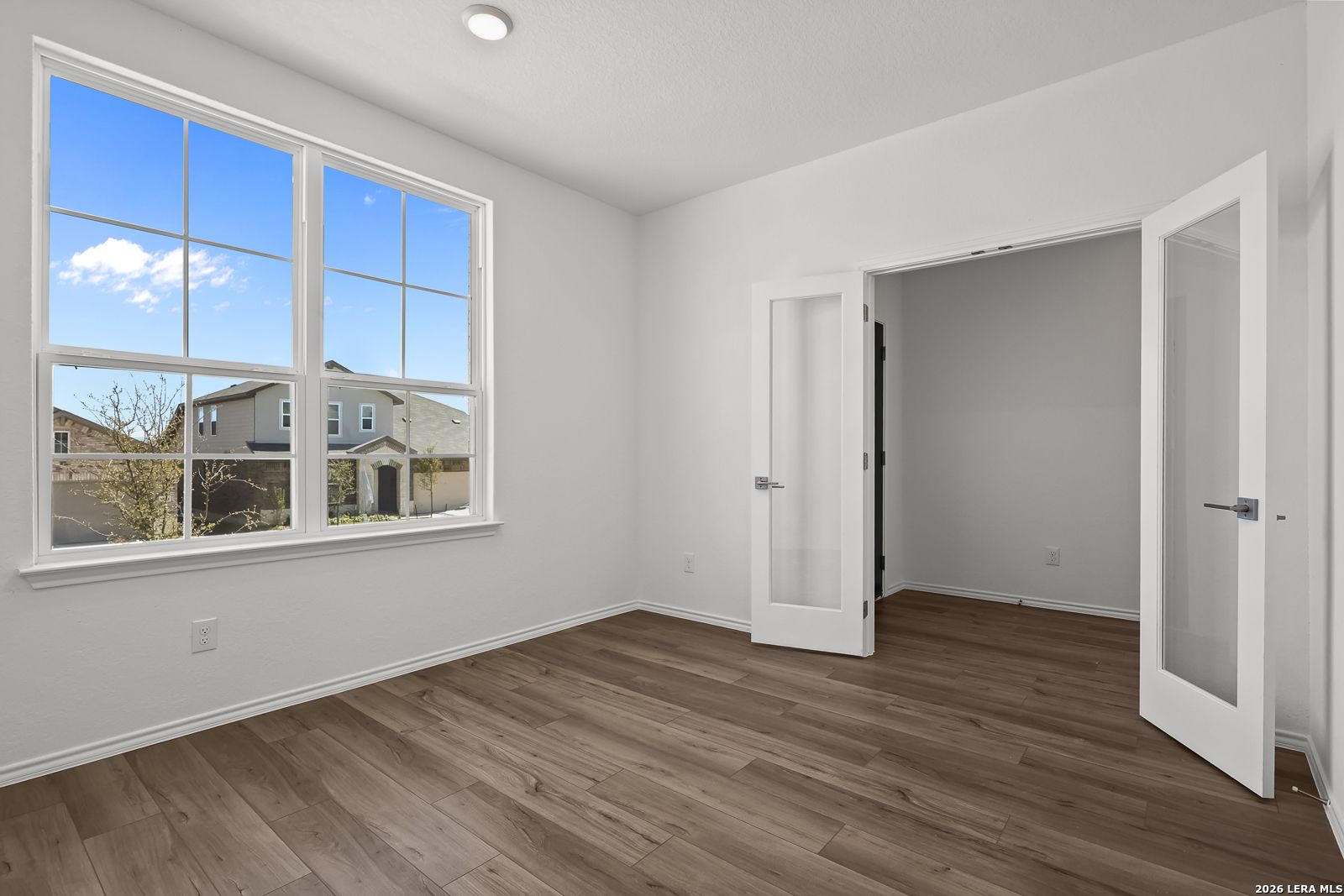 Bright master bedroom with large windows, hardwood floors, and open walk-in closet in Davidson Homes Sequoia B, San Antonio