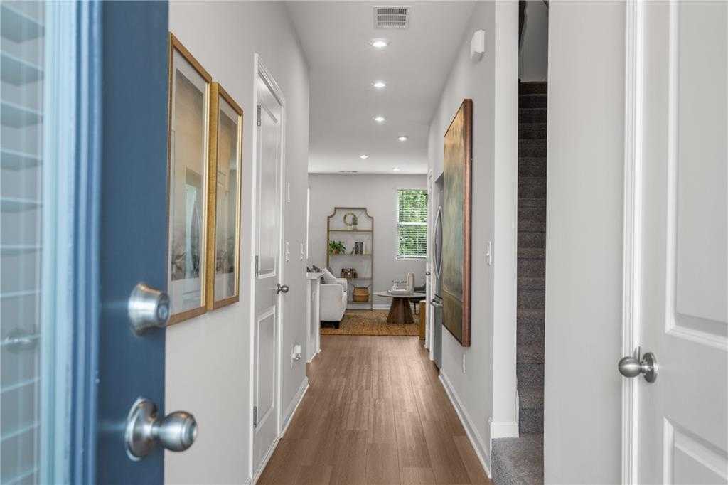 Bright entry hallway with hardwood floors, recessed lights, artwork, and staircase in 3-bedroom Davidson Homes The Durant A, Emerson, GA