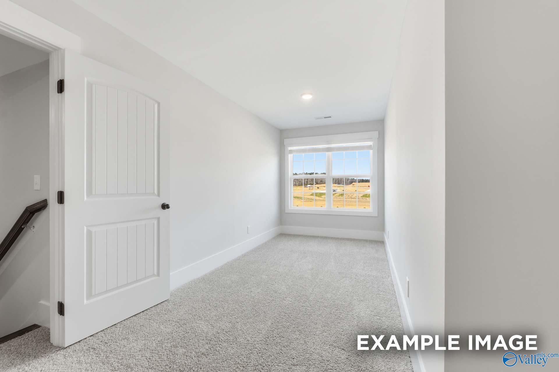 Bright, carpeted bonus room with large windows in The Rockford floor plan by Davidson Homes in Briercreek, Meridianville.