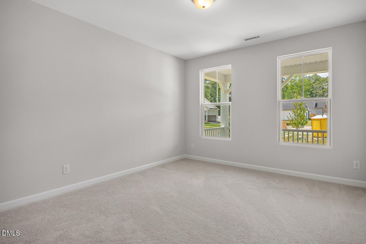 Bright bedroom with neutral carpet in The Hickory II B floor plan by Davidson Homes in Wellers Knoll, Lillington, NC.