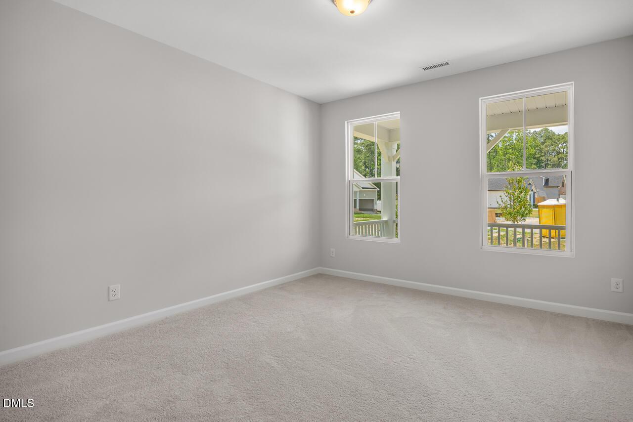 Bright bedroom with neutral carpet in The Hickory II B floor plan by Davidson Homes in Wellers Knoll, Lillington, NC.