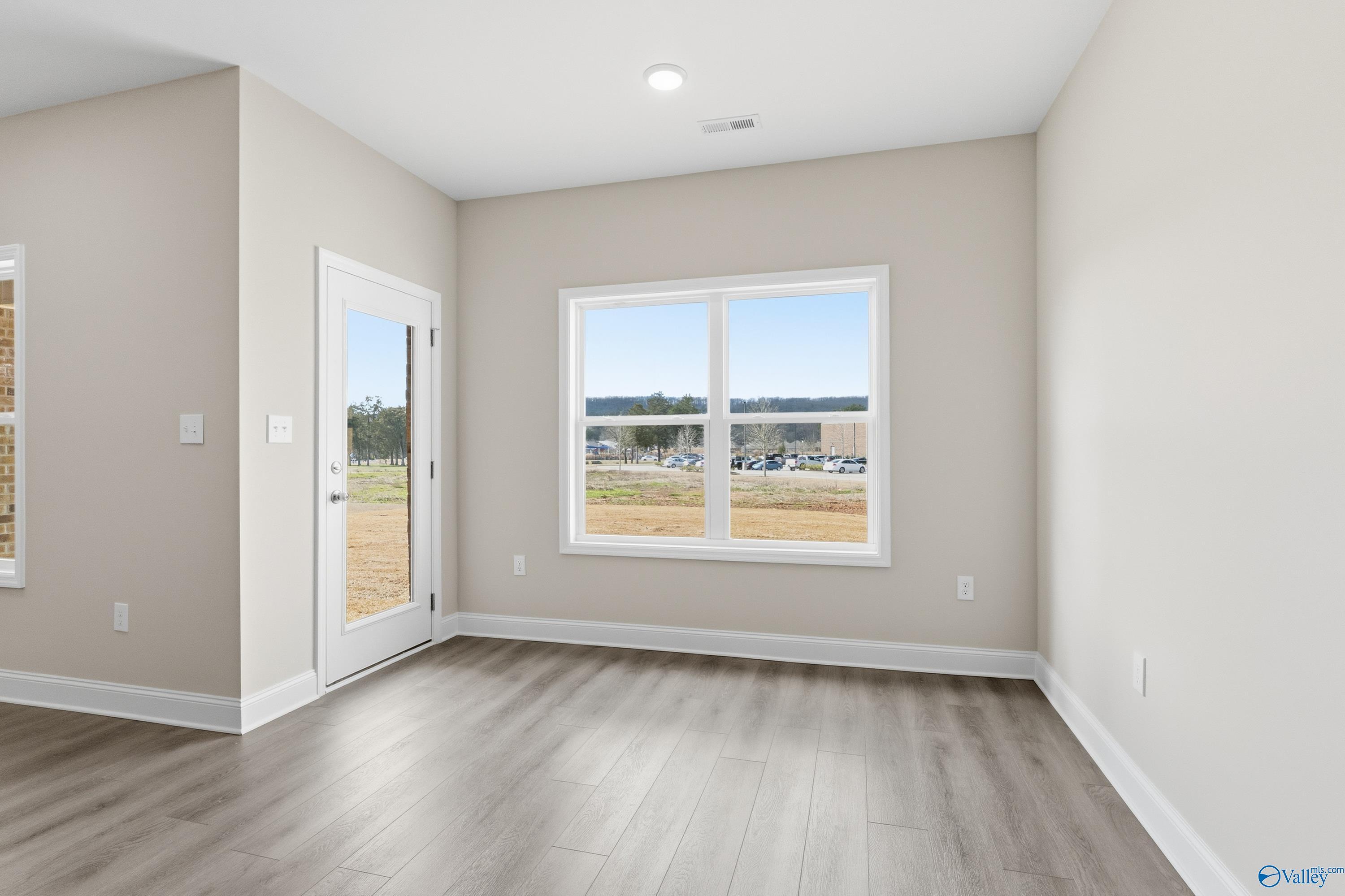 Bright bedroom with large window and glass door overlooking field in The Asheville C, Davidson Homes, Huntsville AL