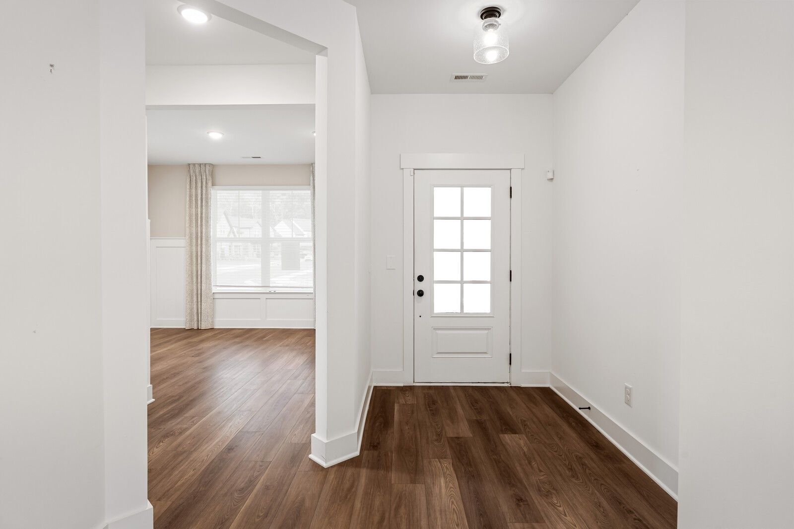 Bright entry foyer with hardwood floors, white trim, and glass-paneled door in Davidson Homes The Ridgeport, Gallatin, TN