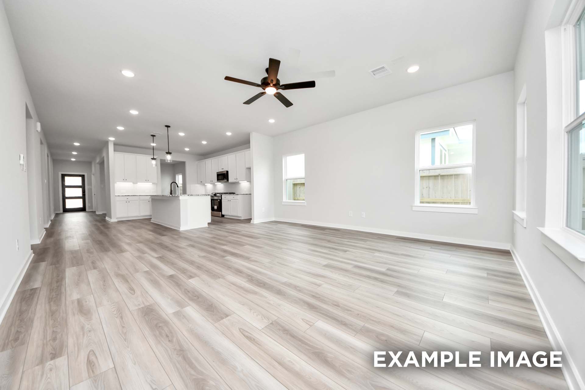 Open-concept living area and kitchen in The Sorrento F by Davidson Homes, featuring modern finishes and wood-look flooring.