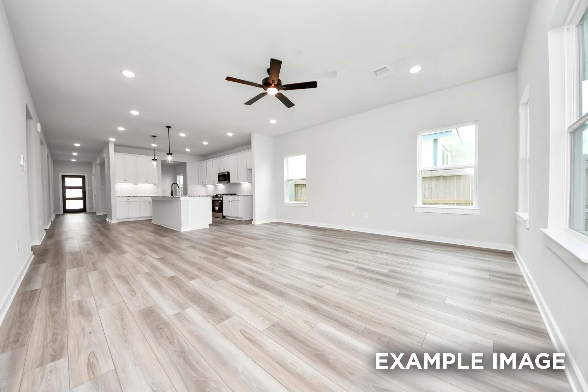 Open-concept living area and kitchen in The Sorrento F by Davidson Homes, featuring modern finishes and wood-look flooring.