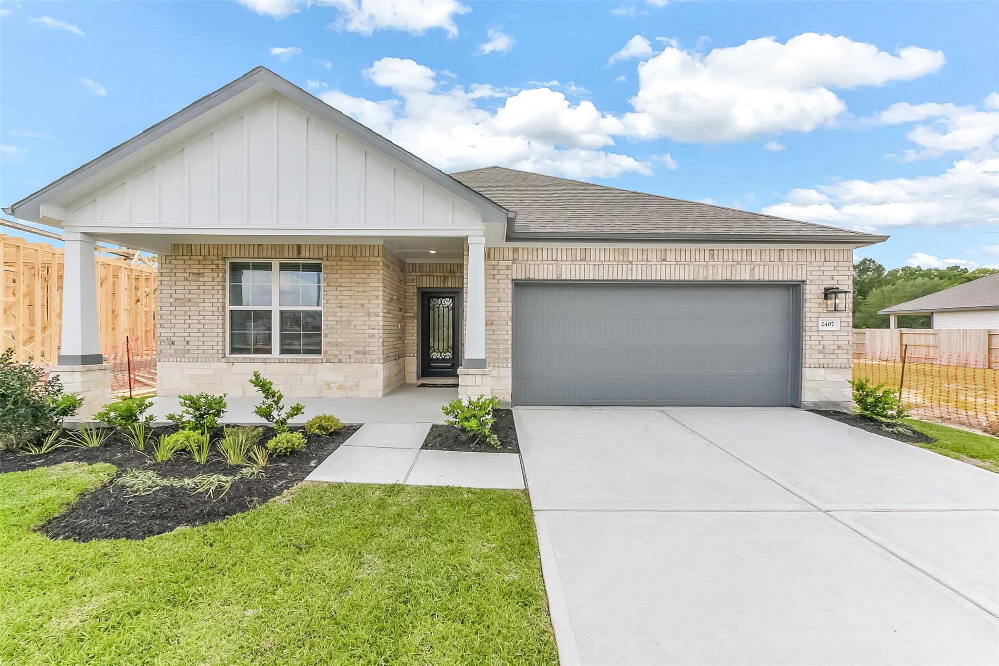 Modern 1-story brick home with covered porch, 2-car garage, and landscaped yard in Sundance Cove, Crosby, Texas by Davidson Homes The Everett C