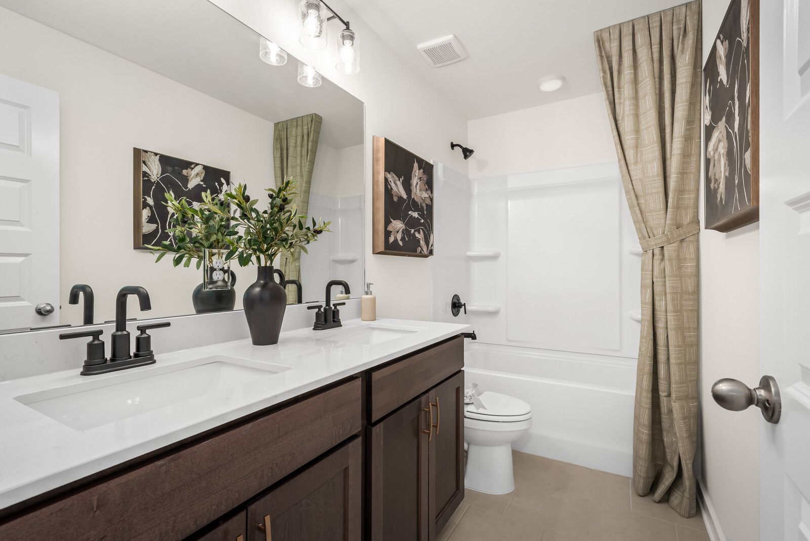 Spacious master bathroom in The Ridgeport E with double vanity, soaking tub, and neutral decor accents
