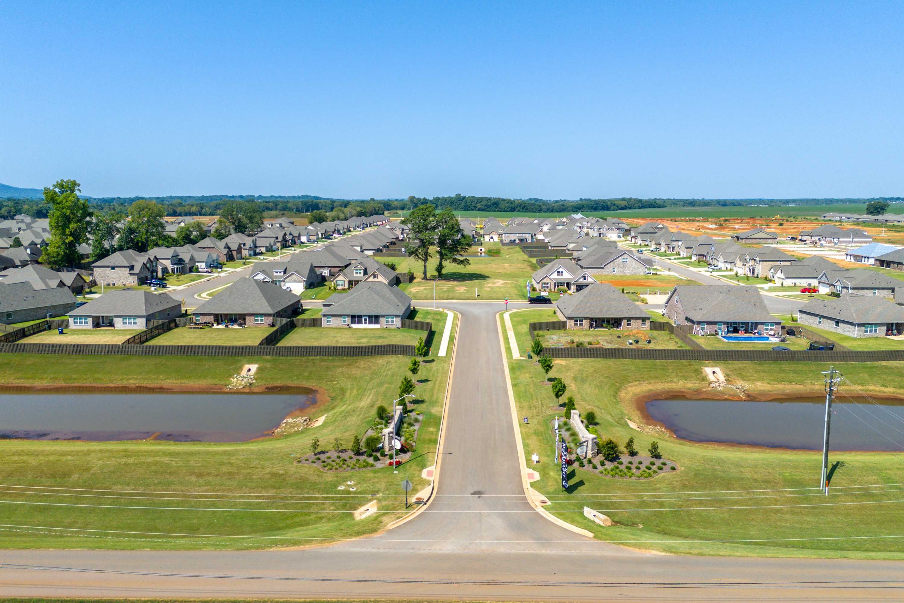 Aerial view of Pikes Ridge neighborhood in Meridianville Alabama with modern homes, landscaped ponds, green lawns and winding roads