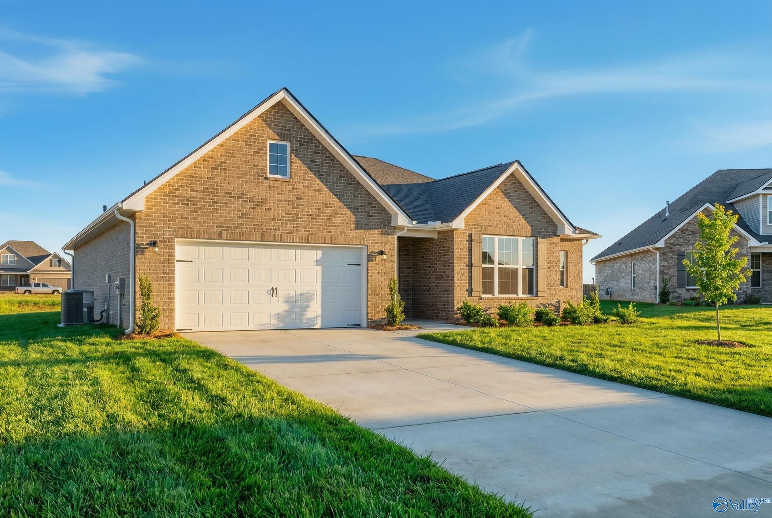 Brick single-story home with 2-car garage, driveway, and lush green lawn in Pikes Ridge, Meridianville, Alabama by Davidson Homes