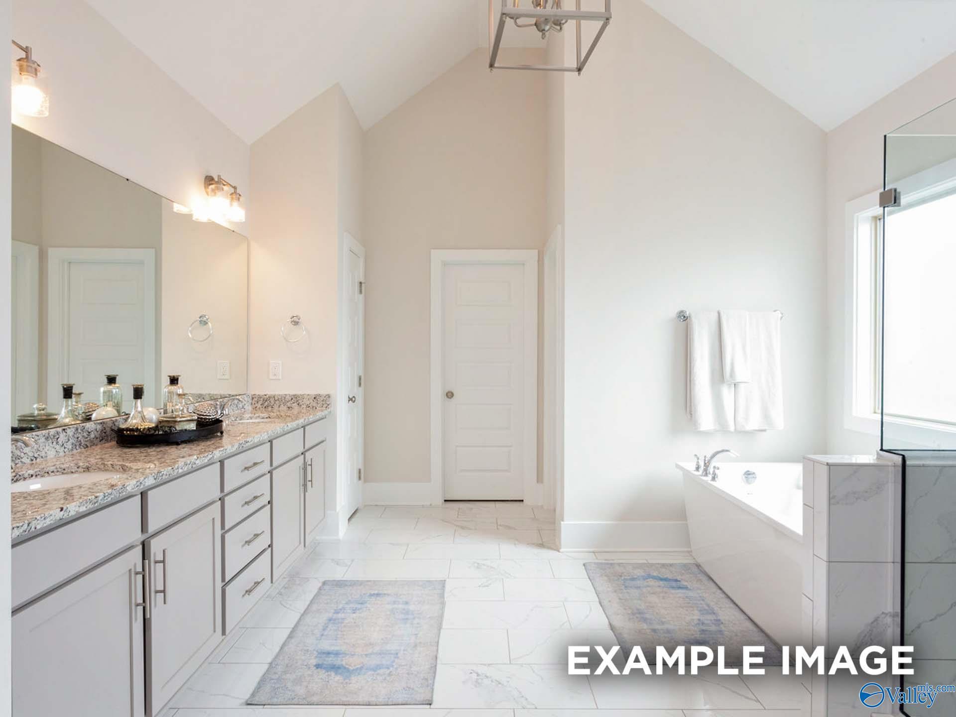 Elegant master bathroom with freestanding tub, glass shower, and double granite vanity in Davidson Homes The Finleigh, Meridianville, Alabama