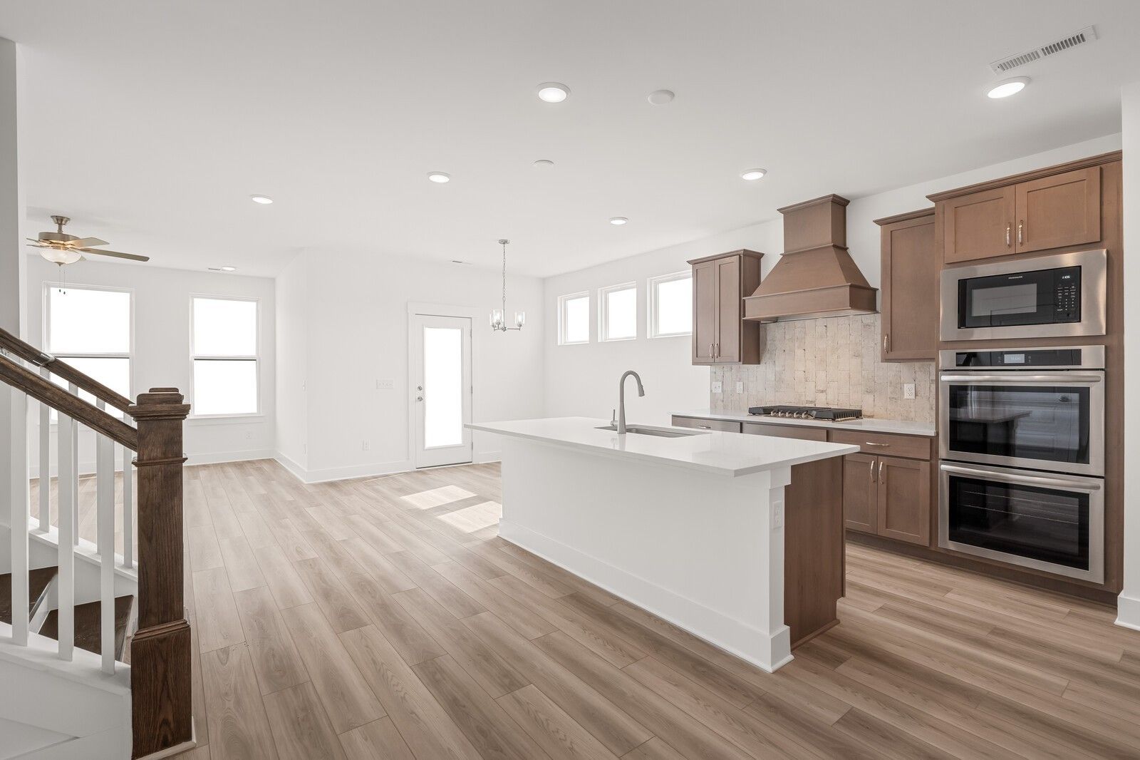 Modern open-concept kitchen with white quartz island, stainless double ovens, subway tile backsplash in Davidson Homes The Ash C, Mt. Juliet
