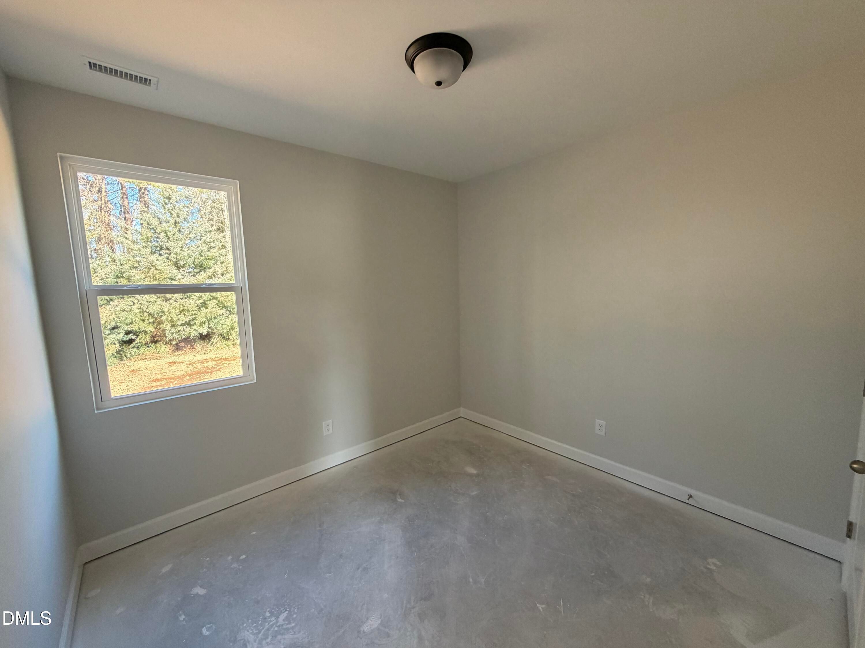 Bright secondary bedroom with beige carpet, gray walls, large window overlooking trees in Davidson Homes The Carter C, Lillington, NC