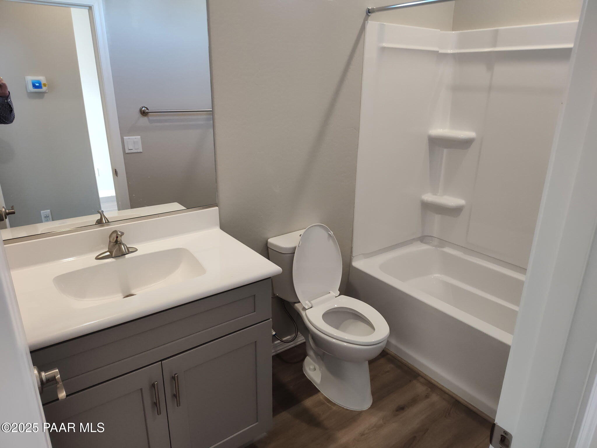 Modern guest bathroom featuring gray vanity, deep soaking tub, walk-in shower, and toilet in Davidson Homes The Frontier A, Prescott Valley, AZ