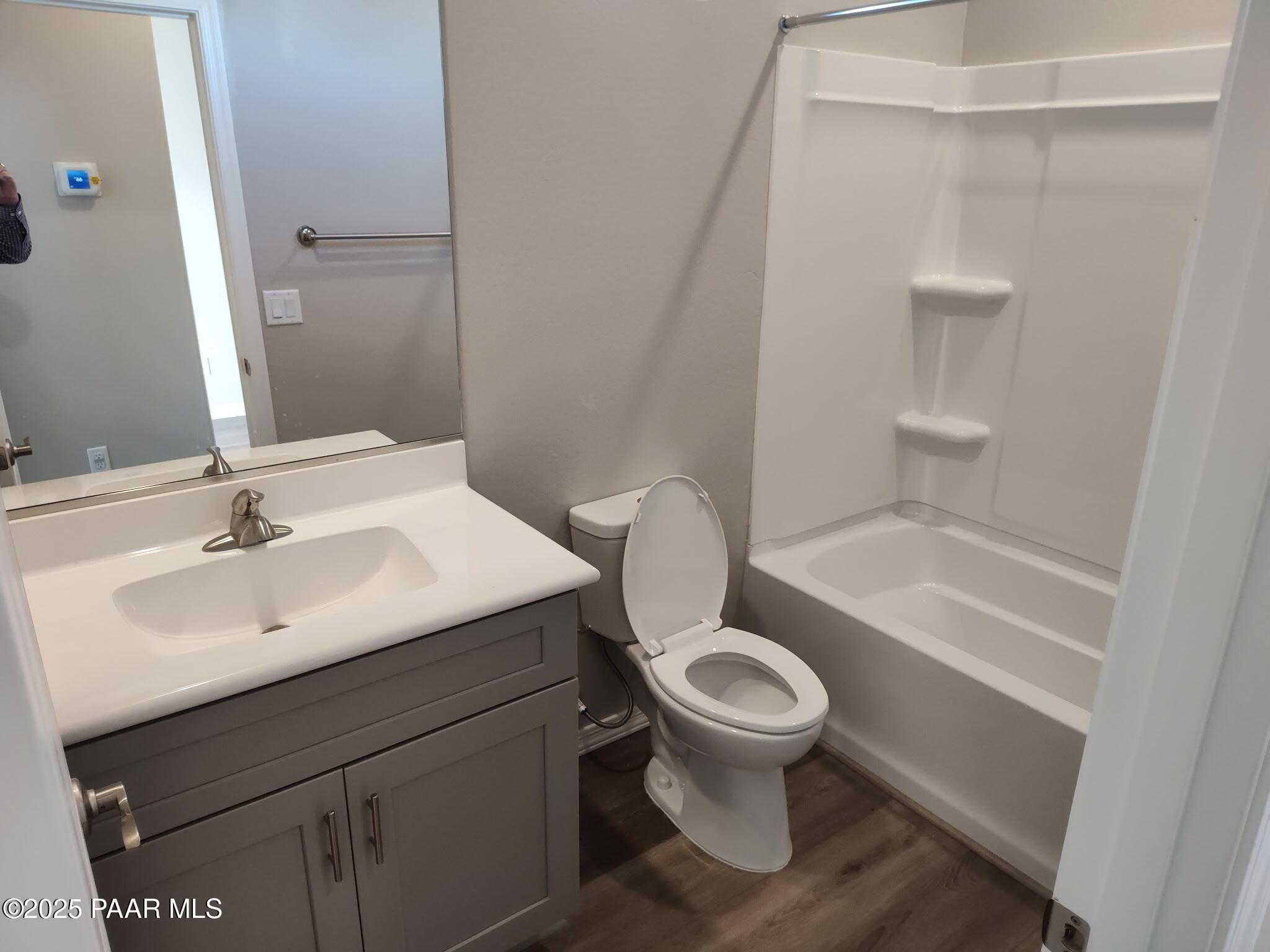 Modern guest bathroom featuring gray vanity, deep soaking tub, walk-in shower, and toilet in Davidson Homes The Frontier A, Prescott Valley, AZ
