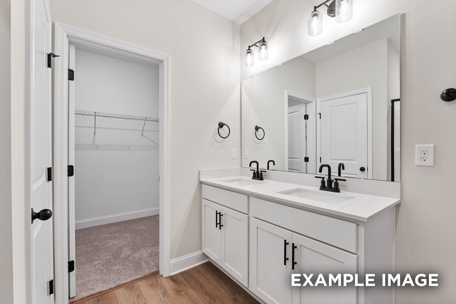 Double vanity bathroom with black fixtures and walk-in closet in The Franklin E floor plan, Bailey Park, Fayetteville, TN.