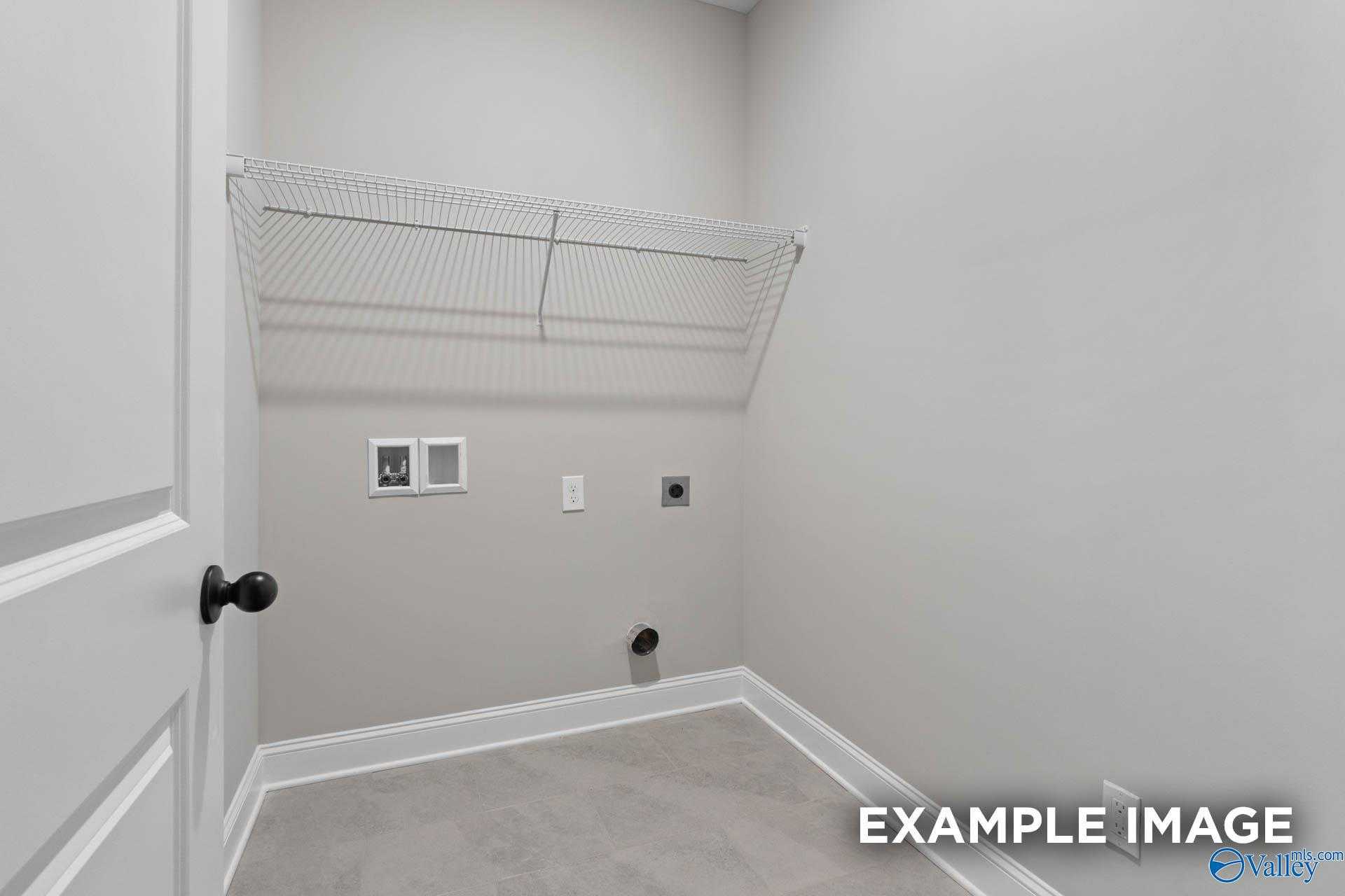 Spacious laundry room with wire shelving and washer-dryer hookups in Davidson Homes Montgomery B, Toney Alabama