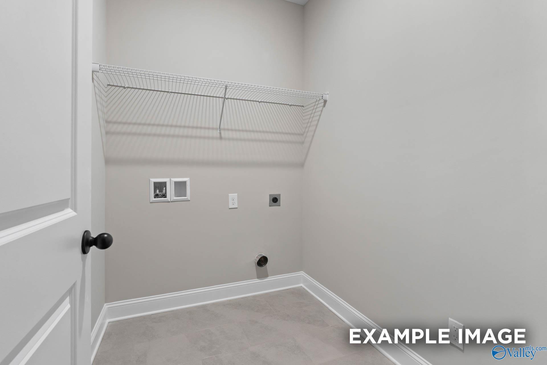 Laundry room with wire shelving and utility hookups in The Montgomery B floor plan by Davidson Homes in Decatur, Alabama.