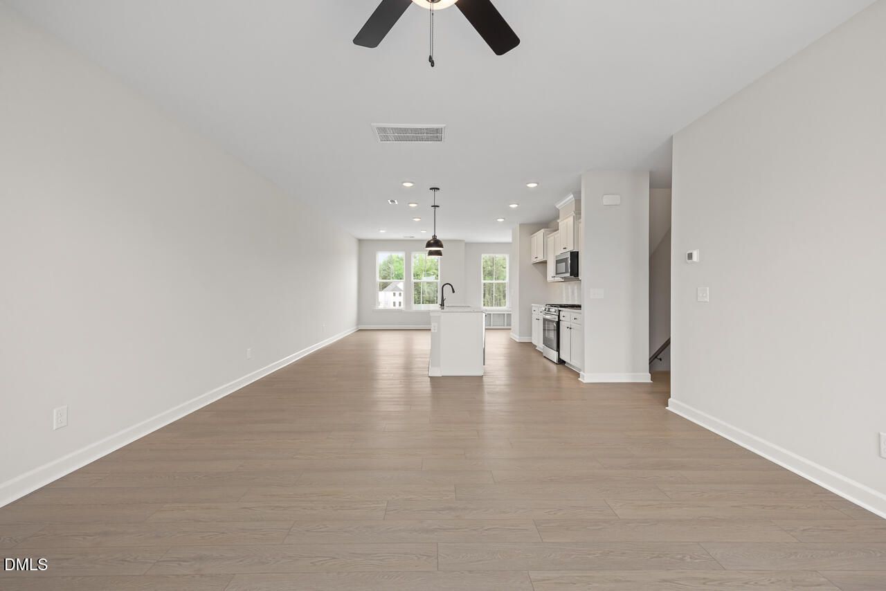 Open-concept living area with hardwood floors in The Mitchell Interior floor plan at Forestville Yard Townhomes, Knightdale.