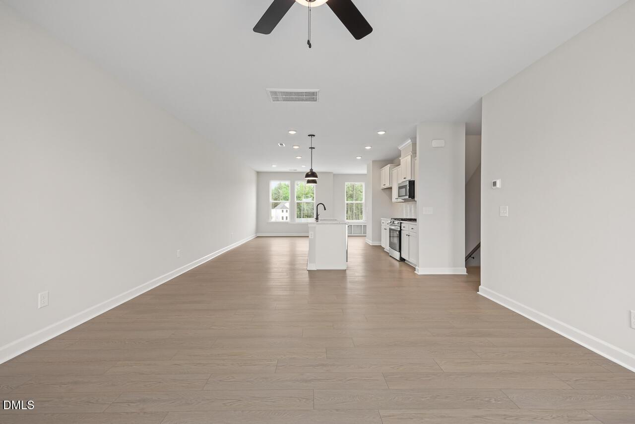 Open-concept living area with hardwood floors in The Mitchell Interior floor plan at Forestville Yard Townhomes, Knightdale.