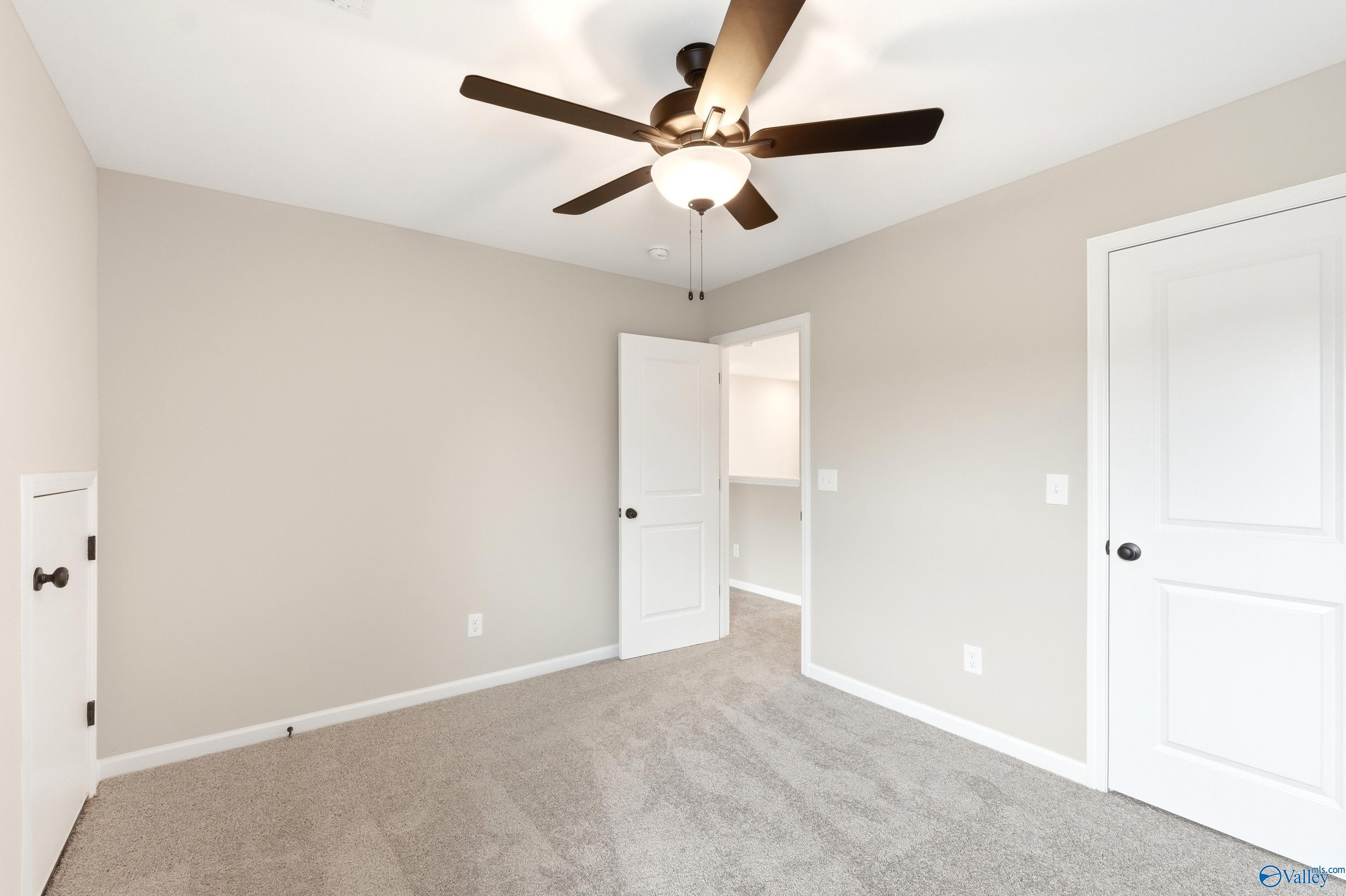 Neutral bedroom with ceiling fan and walk-in closet in The Dorado floor plan at Riverton Preserve, Huntsville, Alabama.