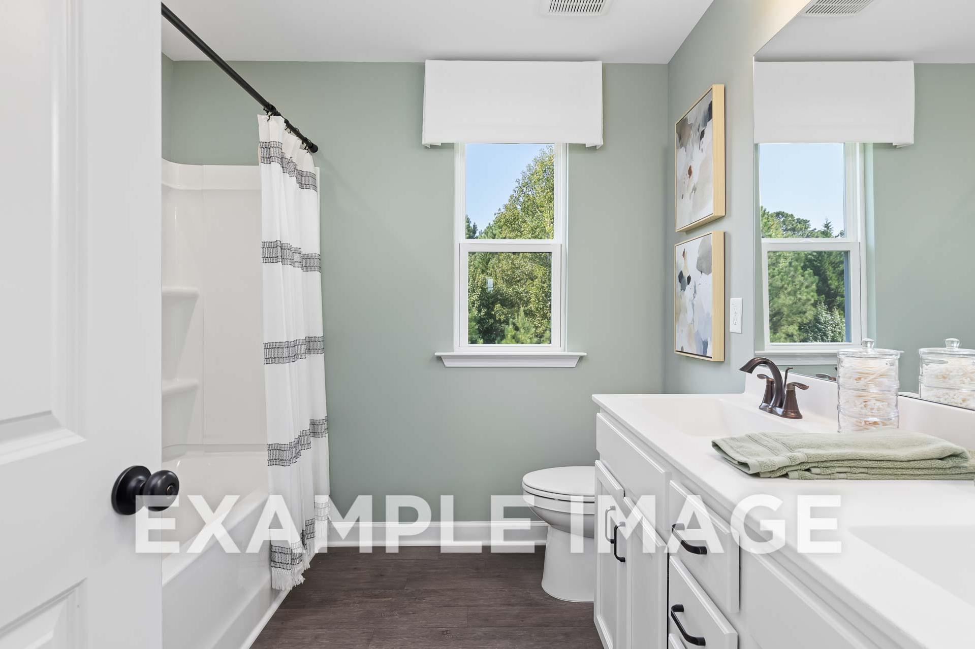 Upper floor master bathroom in The Willow E showcasing walk-in shower, double vanity, and soft green walls