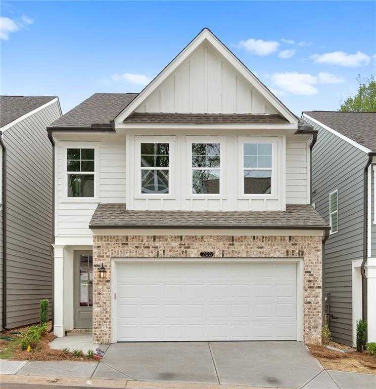 Modern two-story Davidson Homes Marion A with white siding, brick base, two-car garage, and driveway in The Village at Shallowford, Kennesaw, Georgia