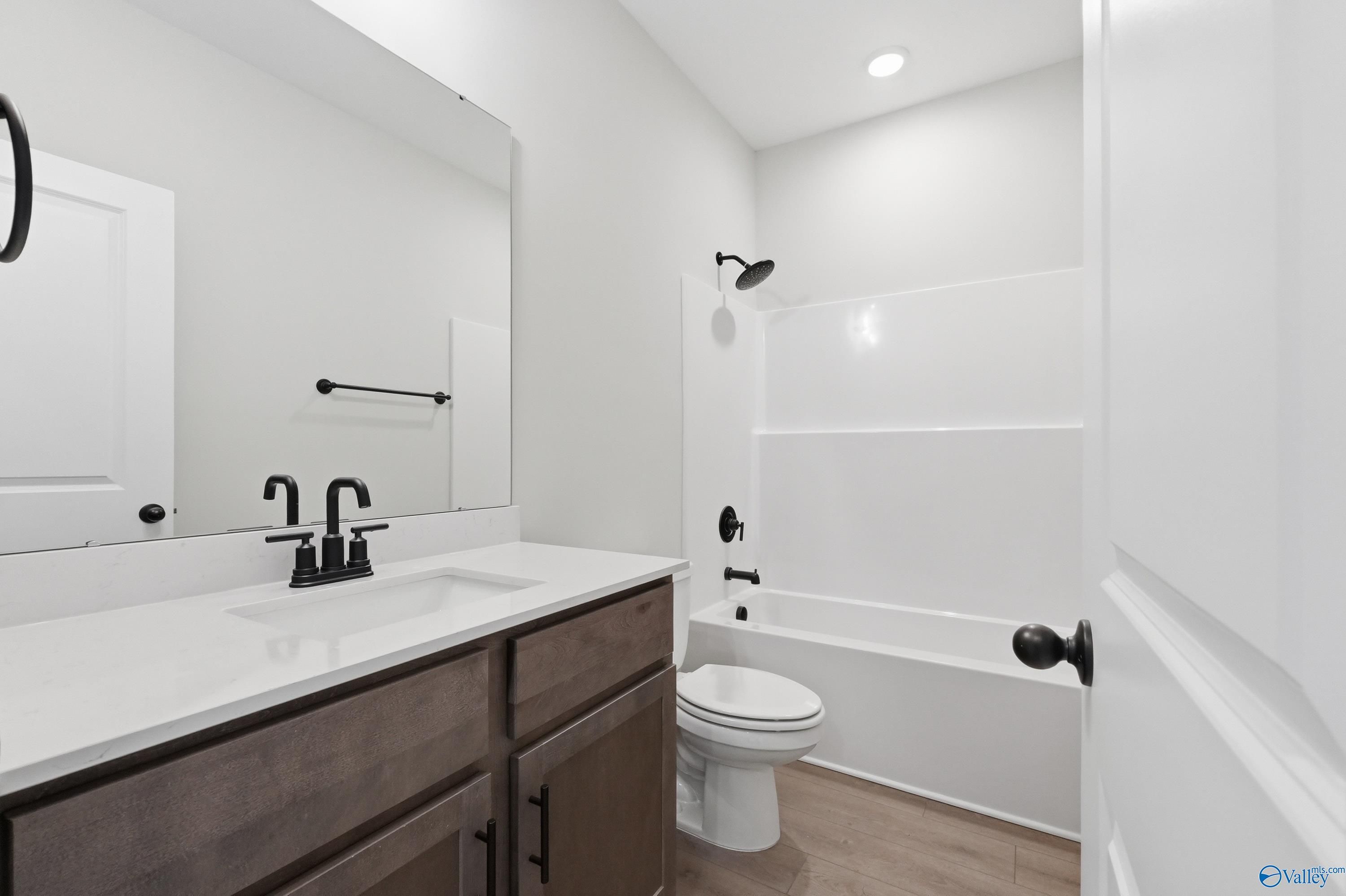 Modern bathroom with white quartz vanity, black fixtures, tub-shower combo in Davidson Homes The Franklin, Huntsville, AL