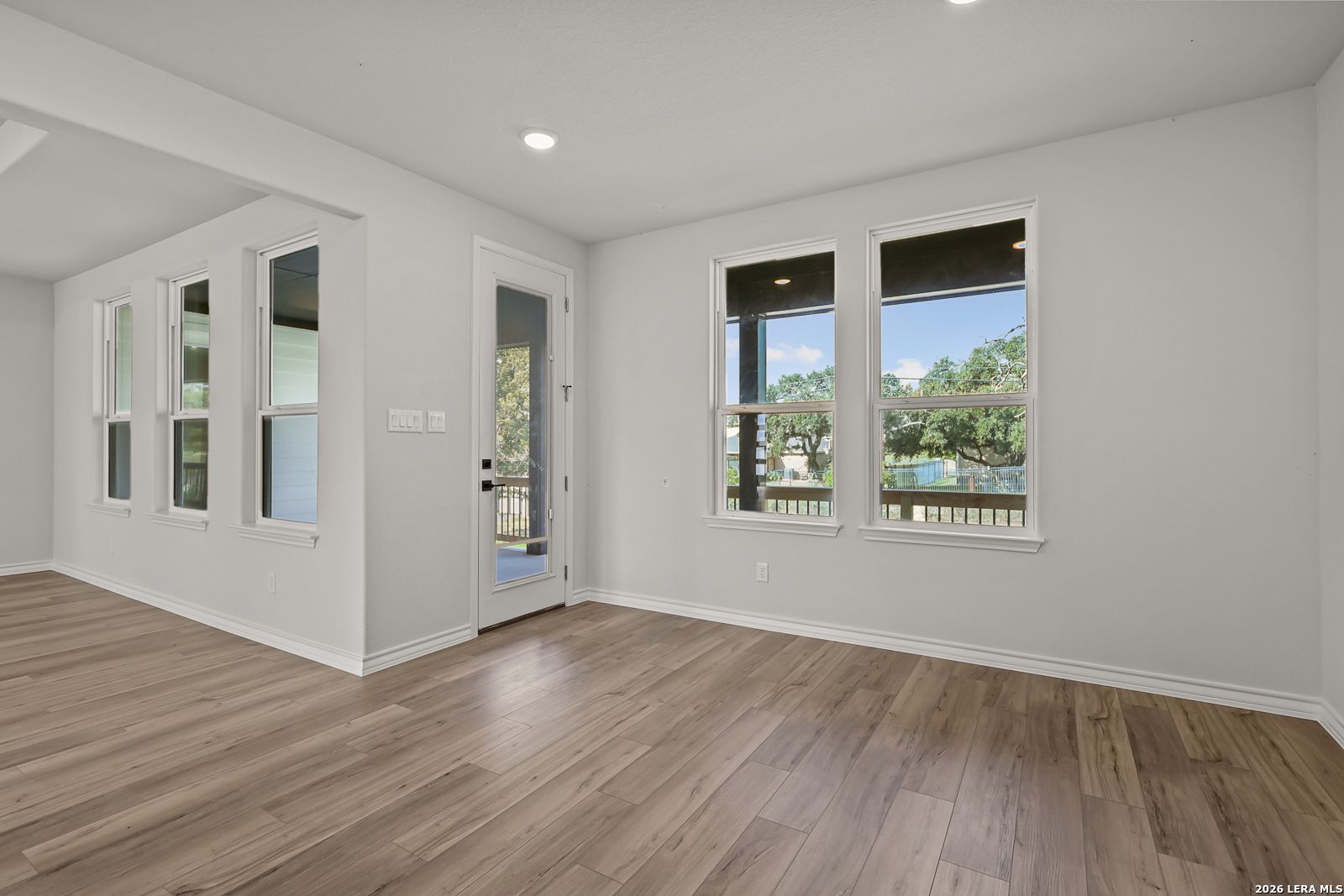 Bright open-concept living room with luxury vinyl plank flooring and backyard views in Davidson Homes The Oxford F, Castroville