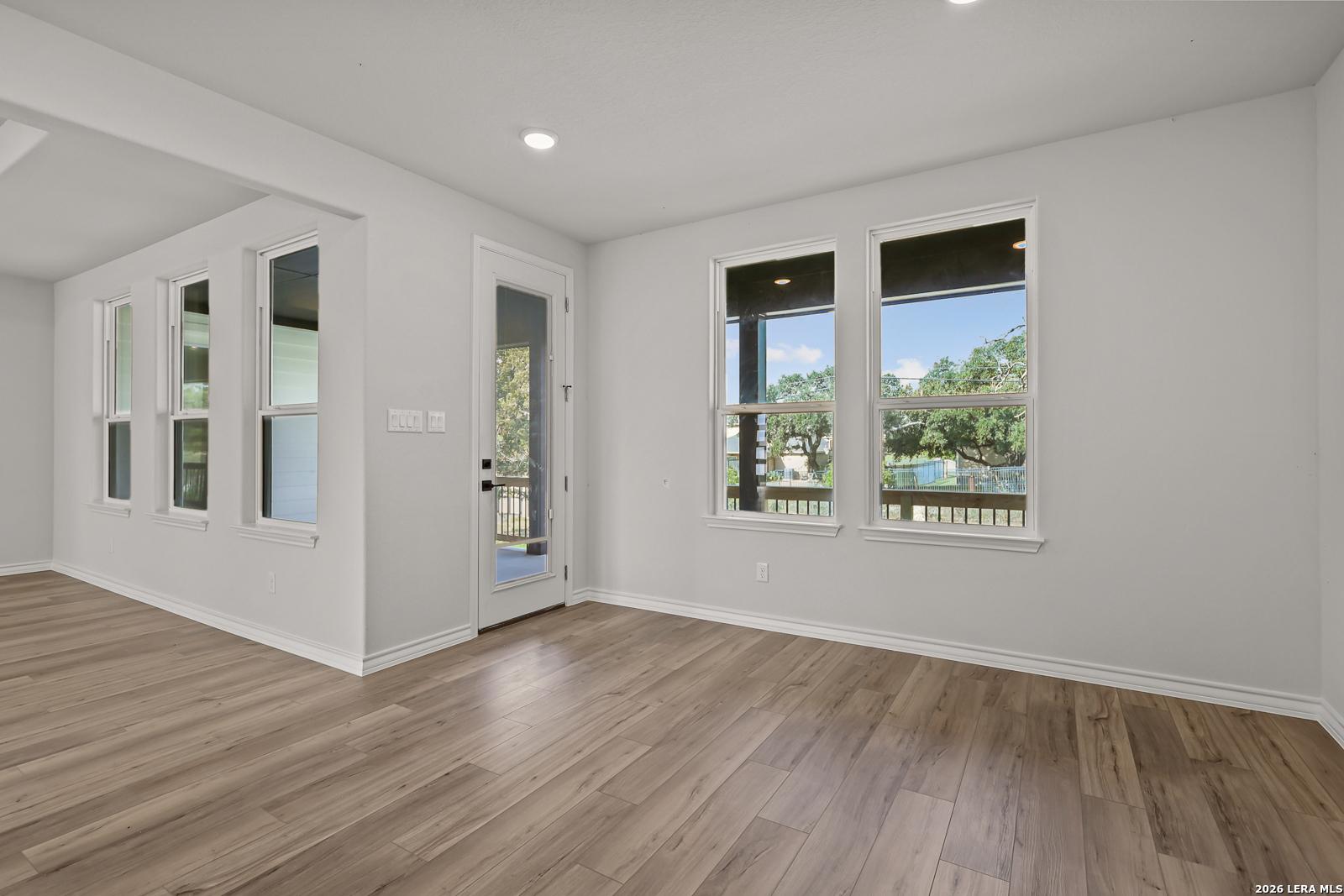 Bright open-concept living room with luxury vinyl plank flooring and backyard views in Davidson Homes The Oxford F, Castroville