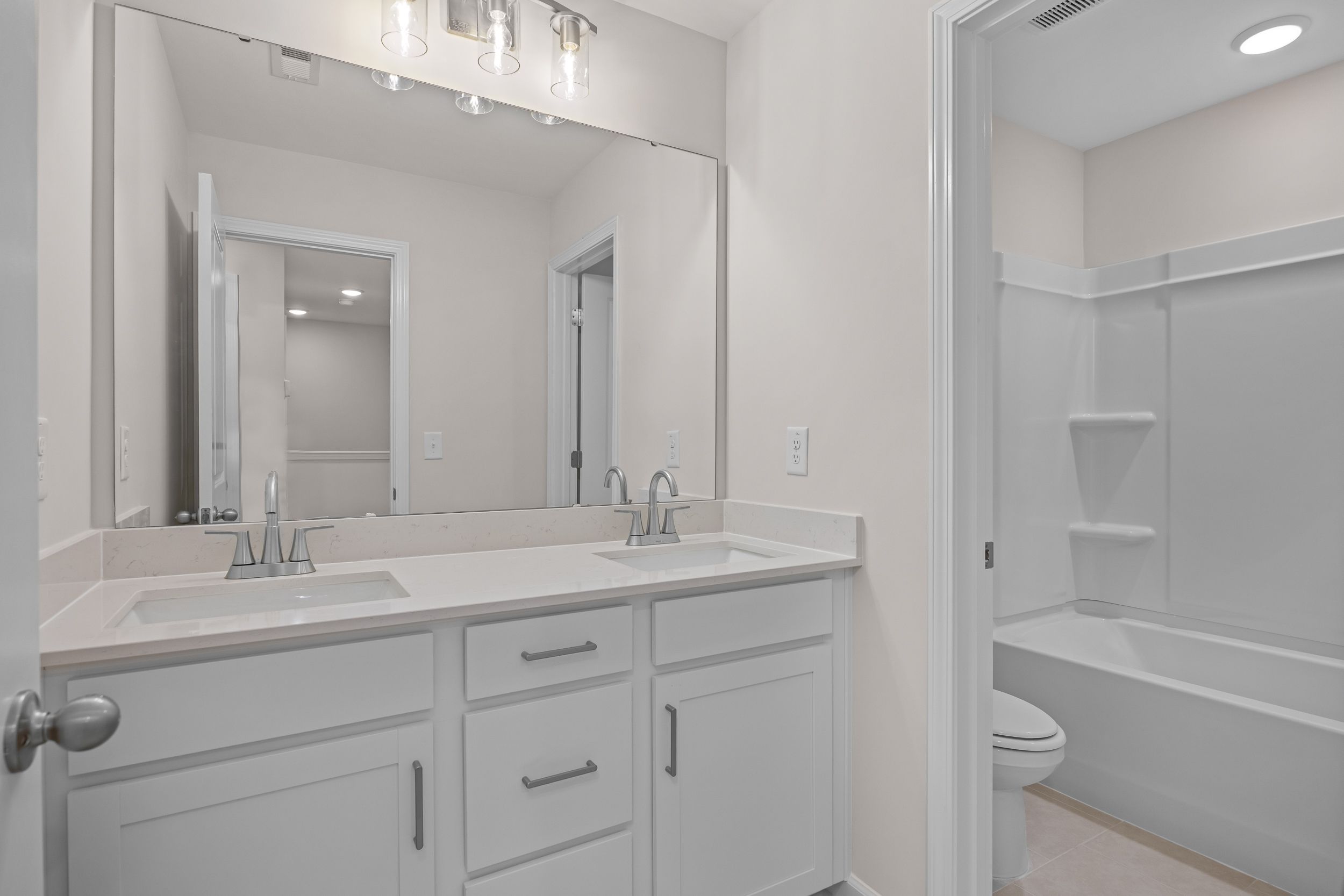Spacious modern bathroom with double vanity, walk-in shower, and tub at Forestville Yard Townhomes in Knightdale, North Carolina