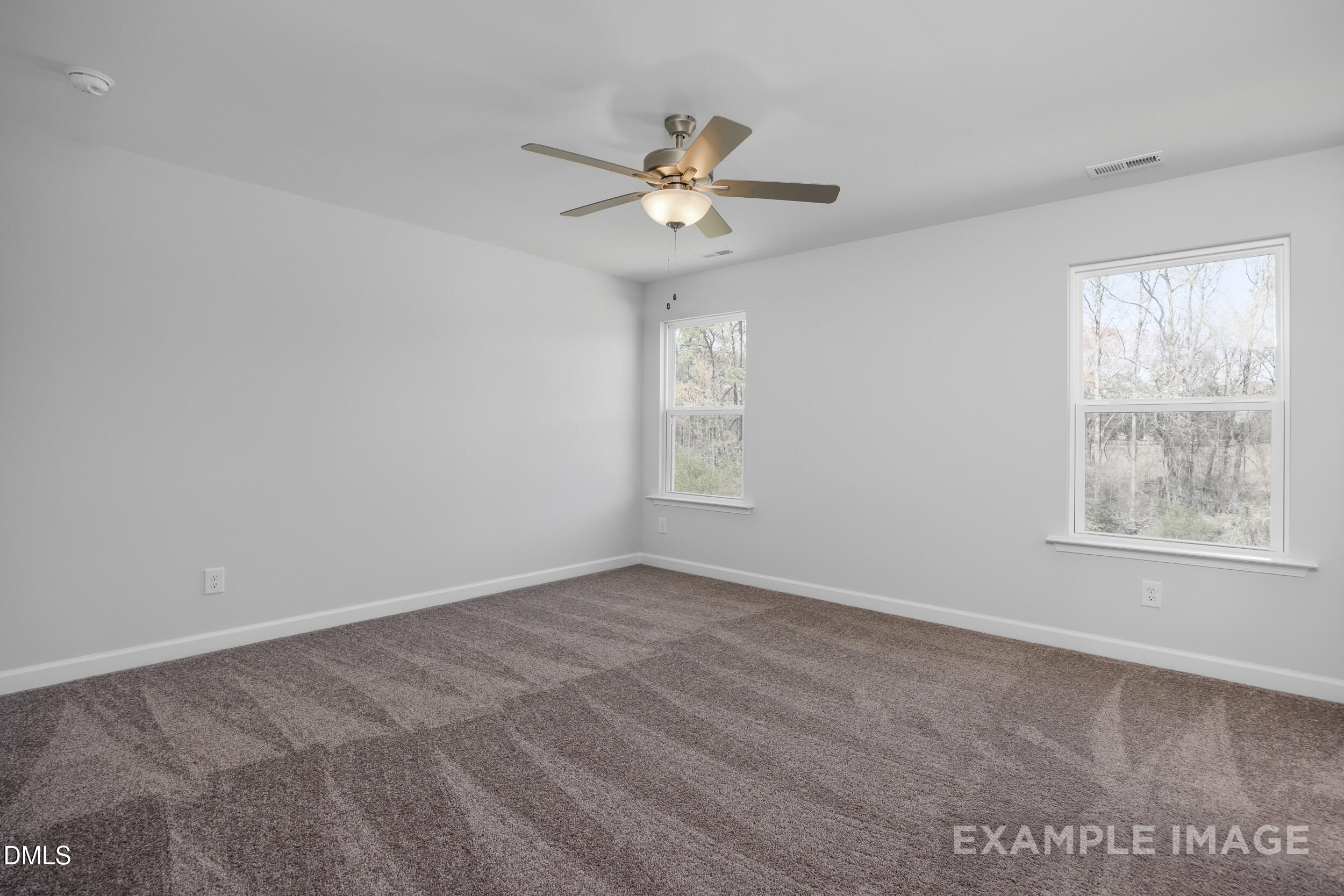Spacious bedroom with grey carpet and ceiling fan in The Gavin A floor plan by Davidson Homes in Gregory Village, Lillington.
