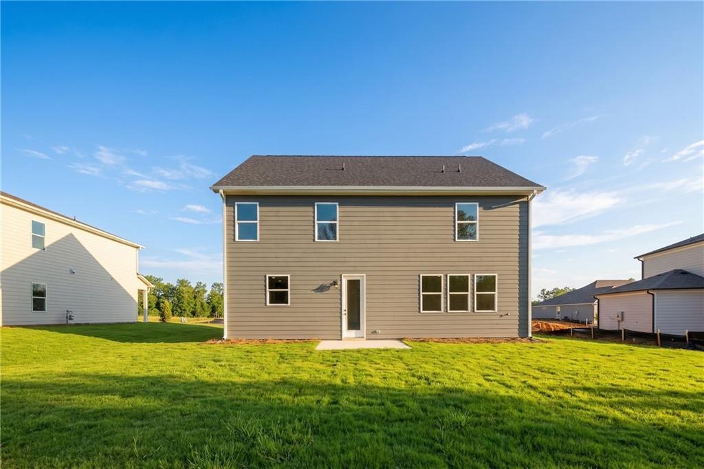 Two-story gray Hickory B home with covered back patio and lush green yard in Cedar Farms, Winder, Georgia
