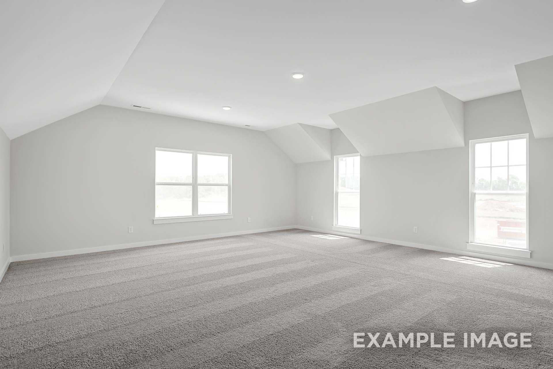 Spacious upstairs bedroom in The Hathaway with vaulted ceiling, large grid windows, gray walls, and plush carpet