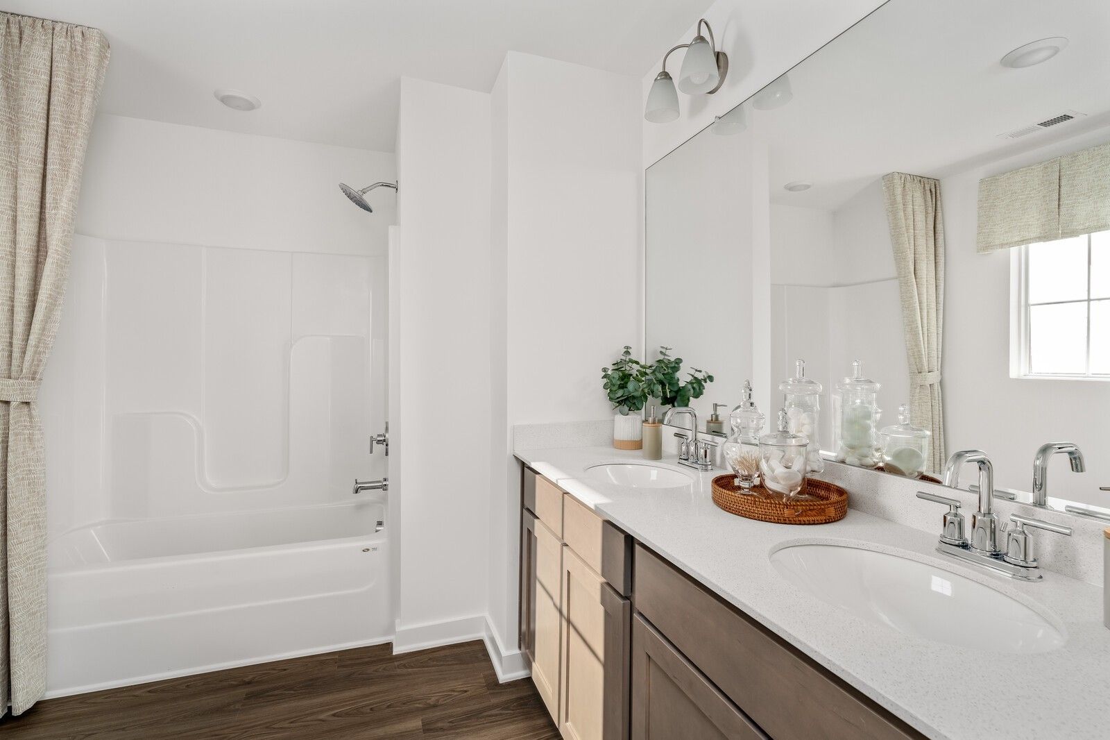 Modern bathroom with deep soaking tub, glass-enclosed shower, and quartz double vanity in Davidson Homes The Cumberland A, Gallatin, TN