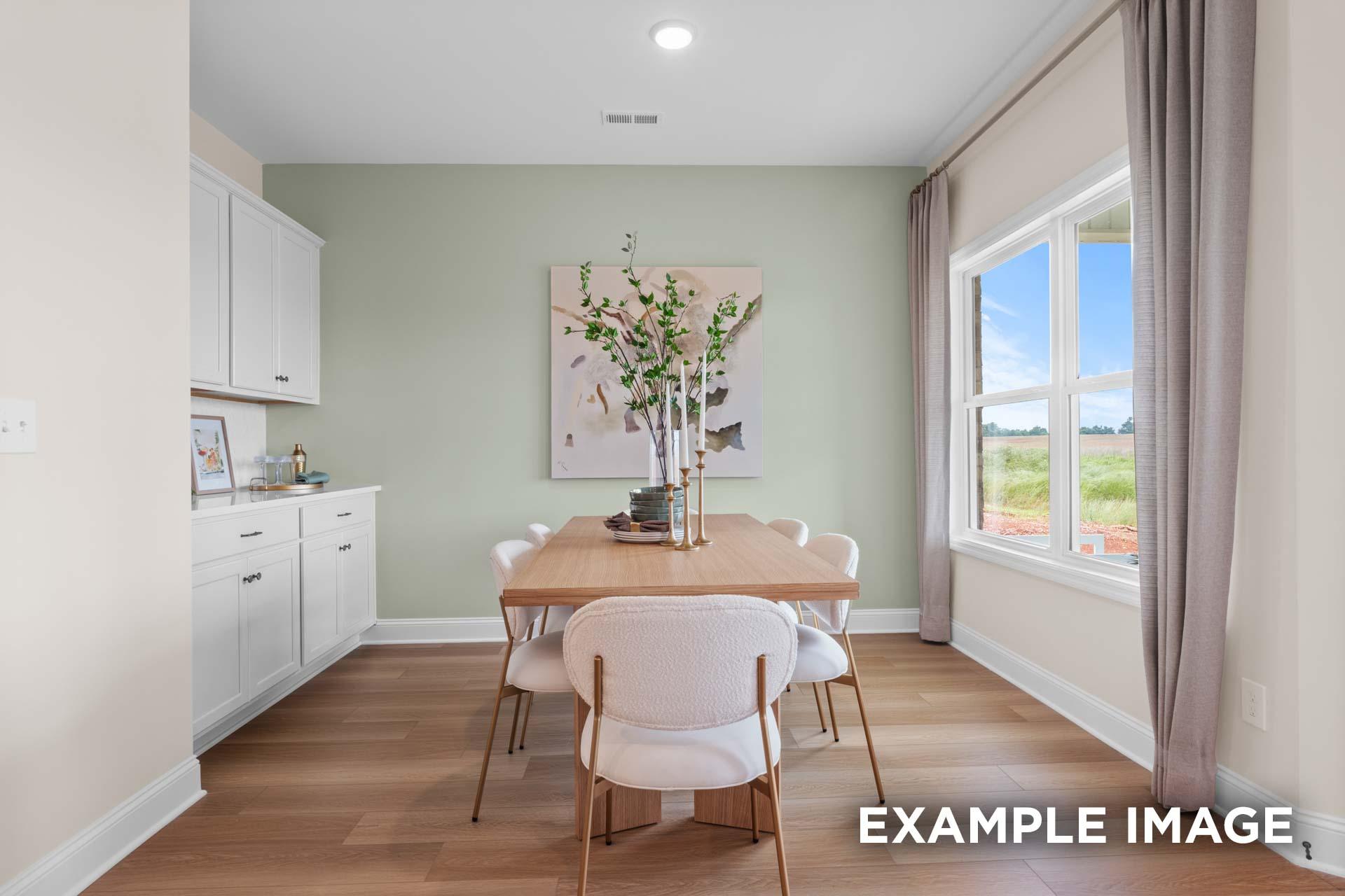 Modern dining room in The Laurel M by Davidson Homes featuring wood table, white chairs, abstract branch art on mint wall, and window view