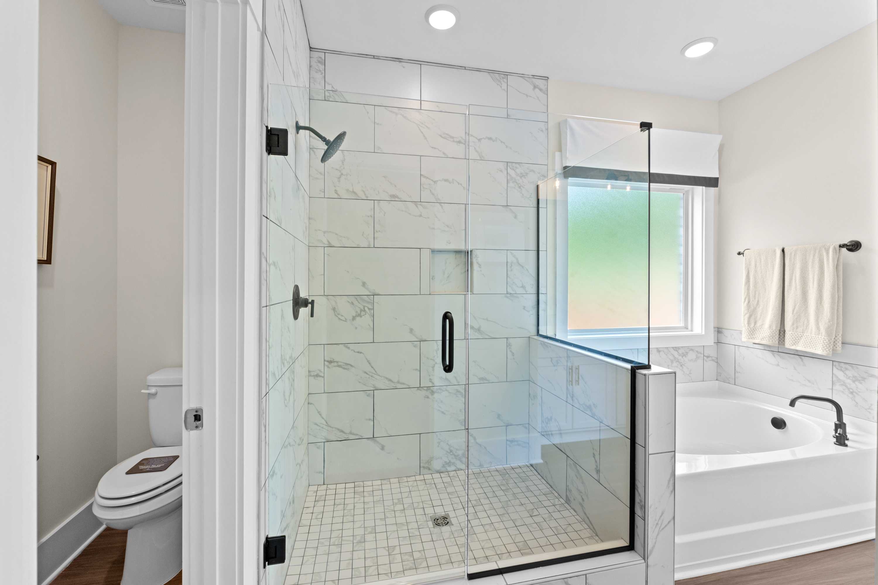 Spa-like master bathroom at Ivy Hills in Toney, Alabama with tiled walk-in shower and freestanding soaking tub