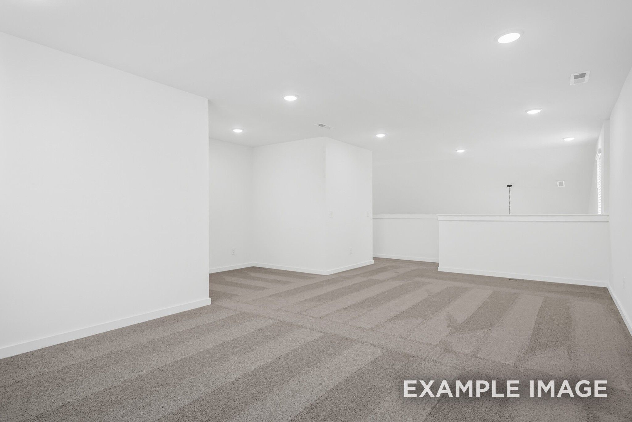 Bright upstairs loft with white walls, striped carpet, and balcony railing in Davidson Homes The Ridgeport C, Gallatin, TN