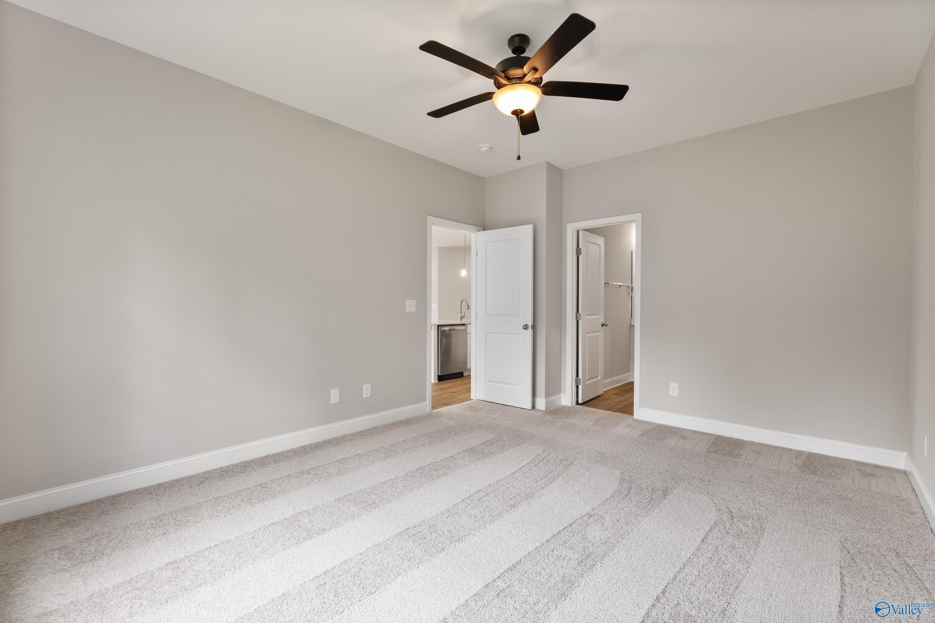 Bright secondary bedroom with gray walls, ceiling fan, carpet flooring, and bathroom access in Davidson Homes The Franklin, Huntsville AL