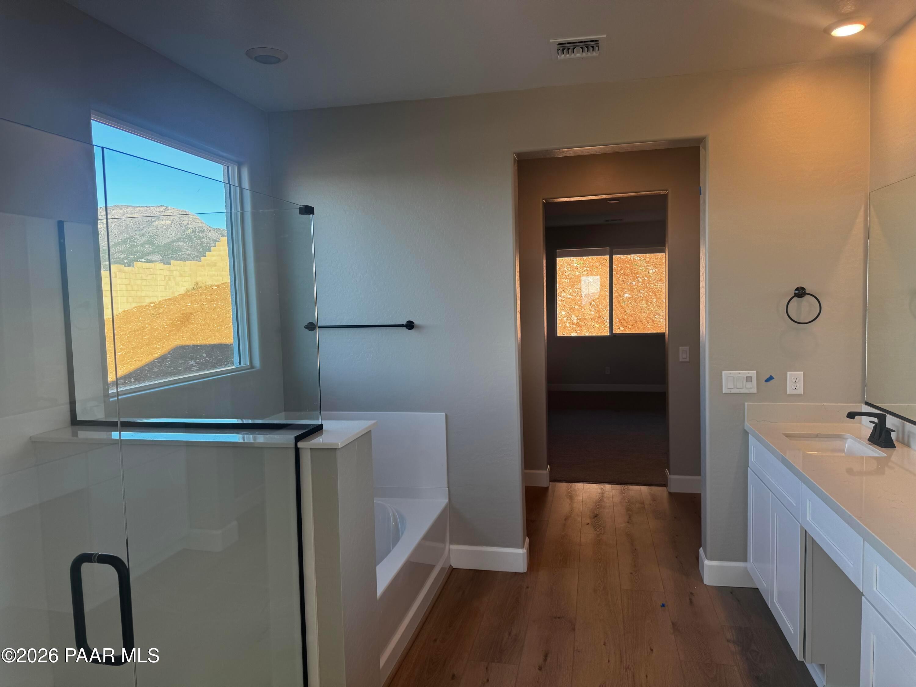 Luxurious master bathroom with glass shower, freestanding tub, double vanity, and mountain view in Evermore Homes The Monarch B, Prescott Valley, AZ