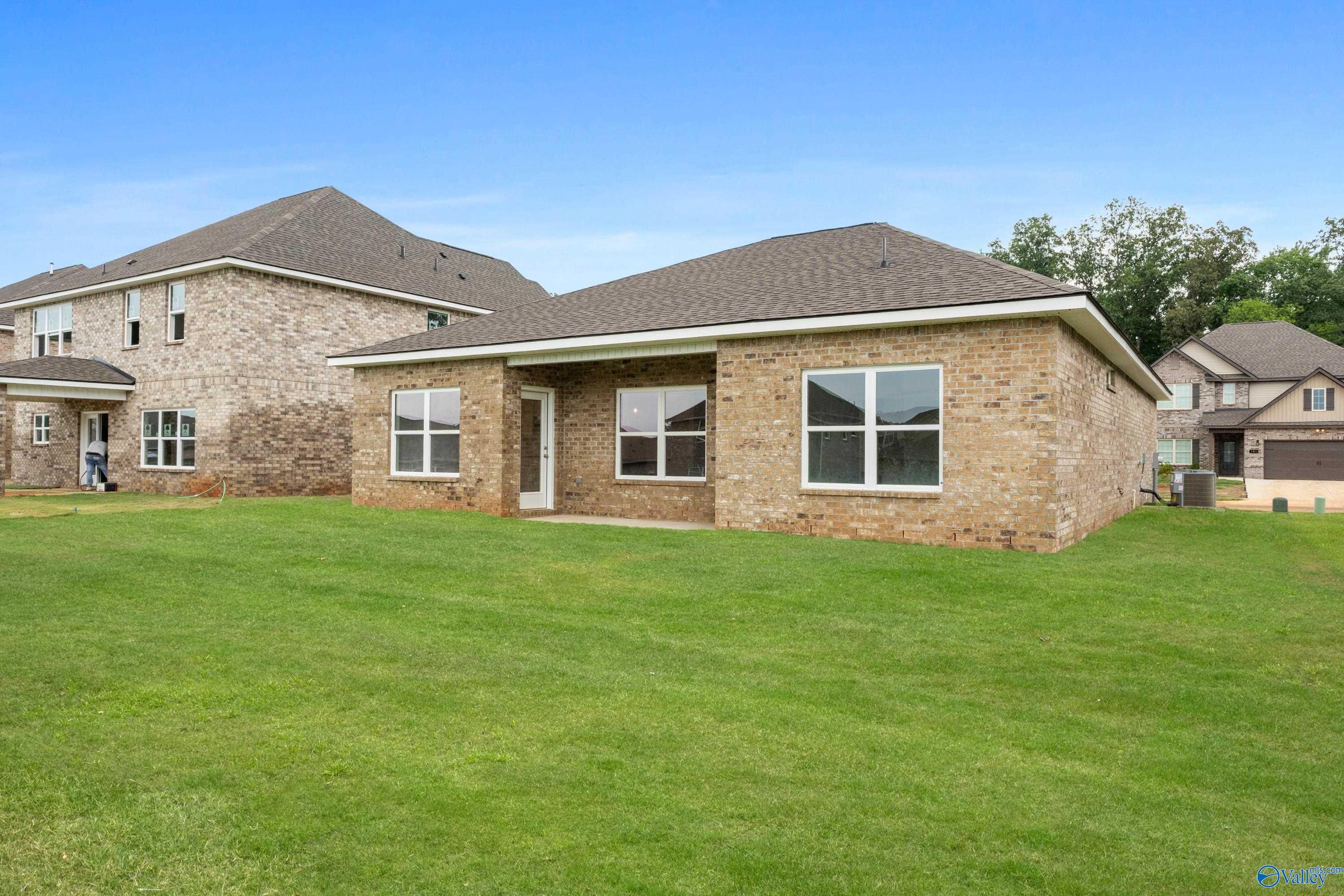 Brick single-story 3-bedroom home with 2-car garage and large windows on lush green lawn in Creek Grove, New Market, Alabama - Davidson Homes Asheville C