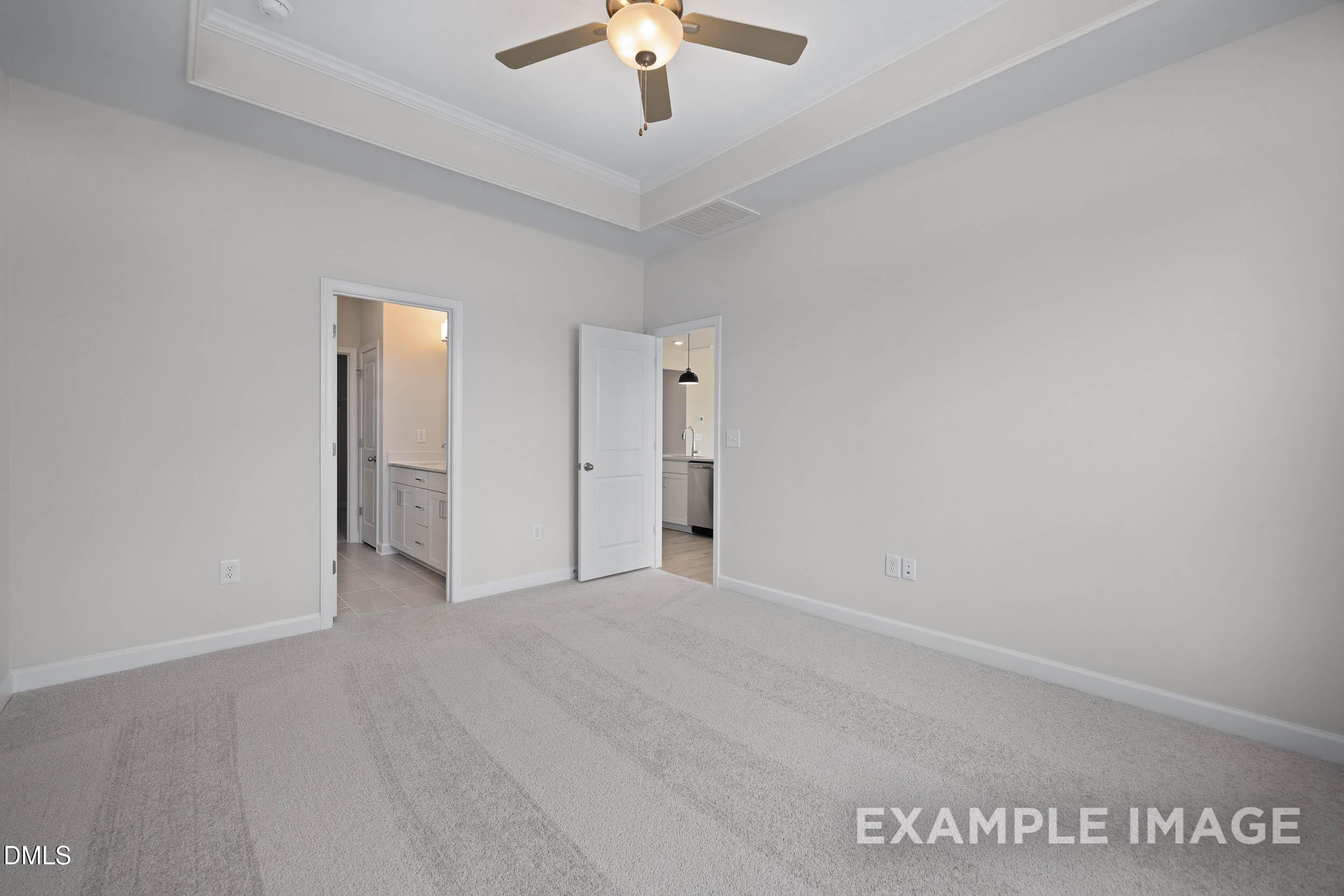 Spacious bedroom with tray ceiling and ceiling fan in The Franklin C floor plan at Retreat at North Main, Lillington, NC.