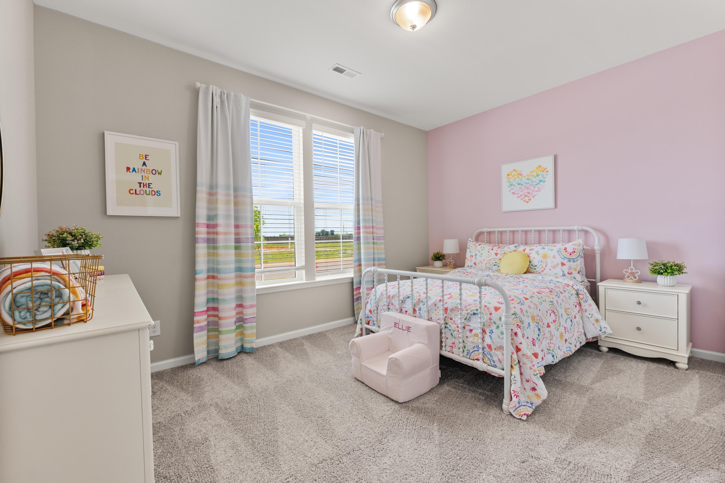 Pink girl's bedroom at The Meadows at Hampton Cove in Owens Cross Roads AL with floral bedding, colorful curtains and wall art
