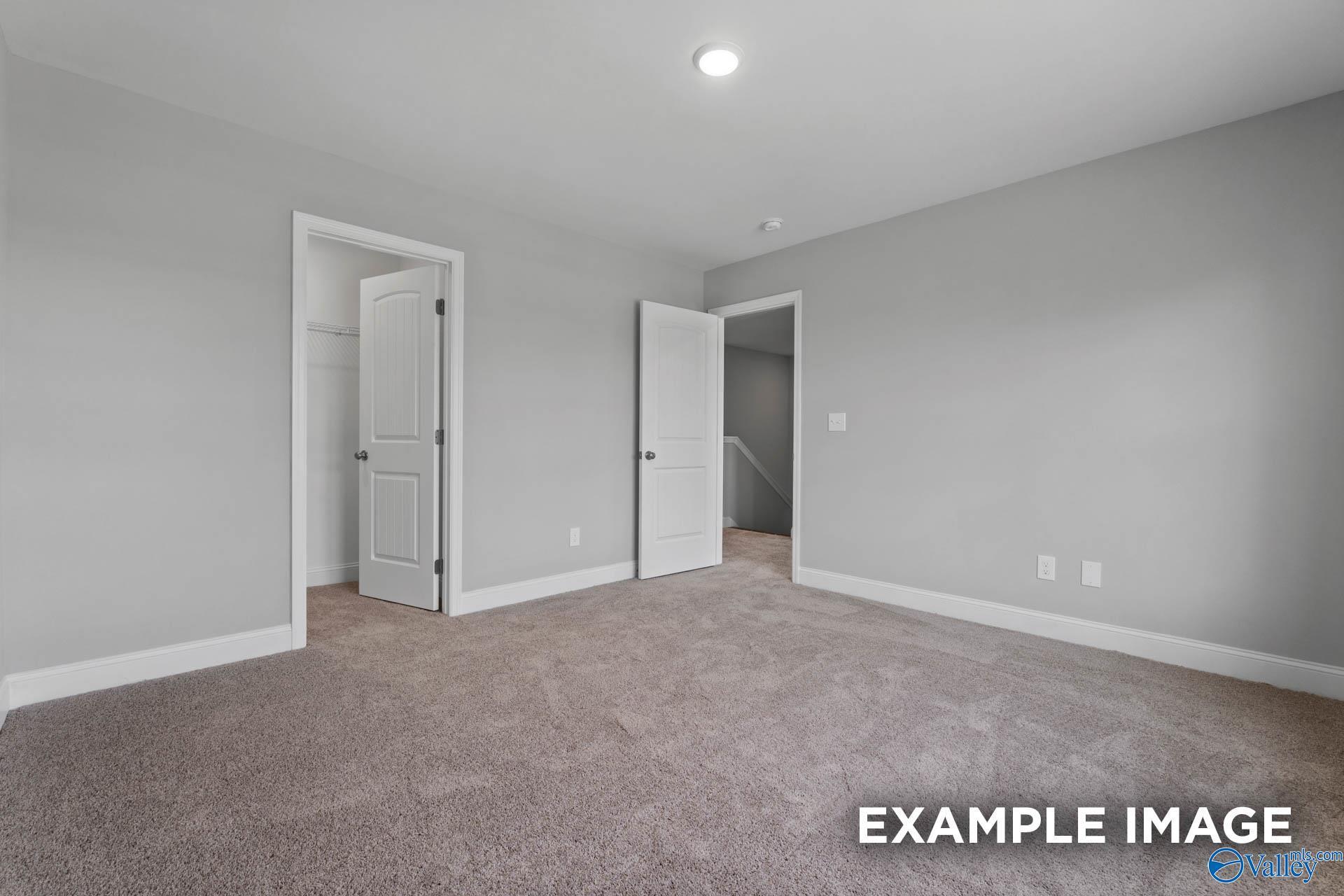 Empty secondary bedroom featuring gray walls, beige carpet, and bathroom access in Davidson Homes The Shelby B, New Market, Alabama