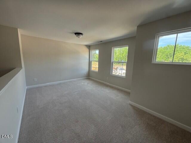 Spacious carpeted loft area in The Willow B floor plan at Woodland Crossing in Zebulon, North Carolina.