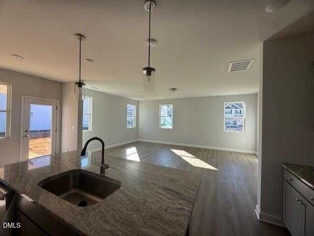 Open-concept kitchen with quartz island, undermount sink, and natural light in The Gavin B 3-bedroom home, Lillington, NC