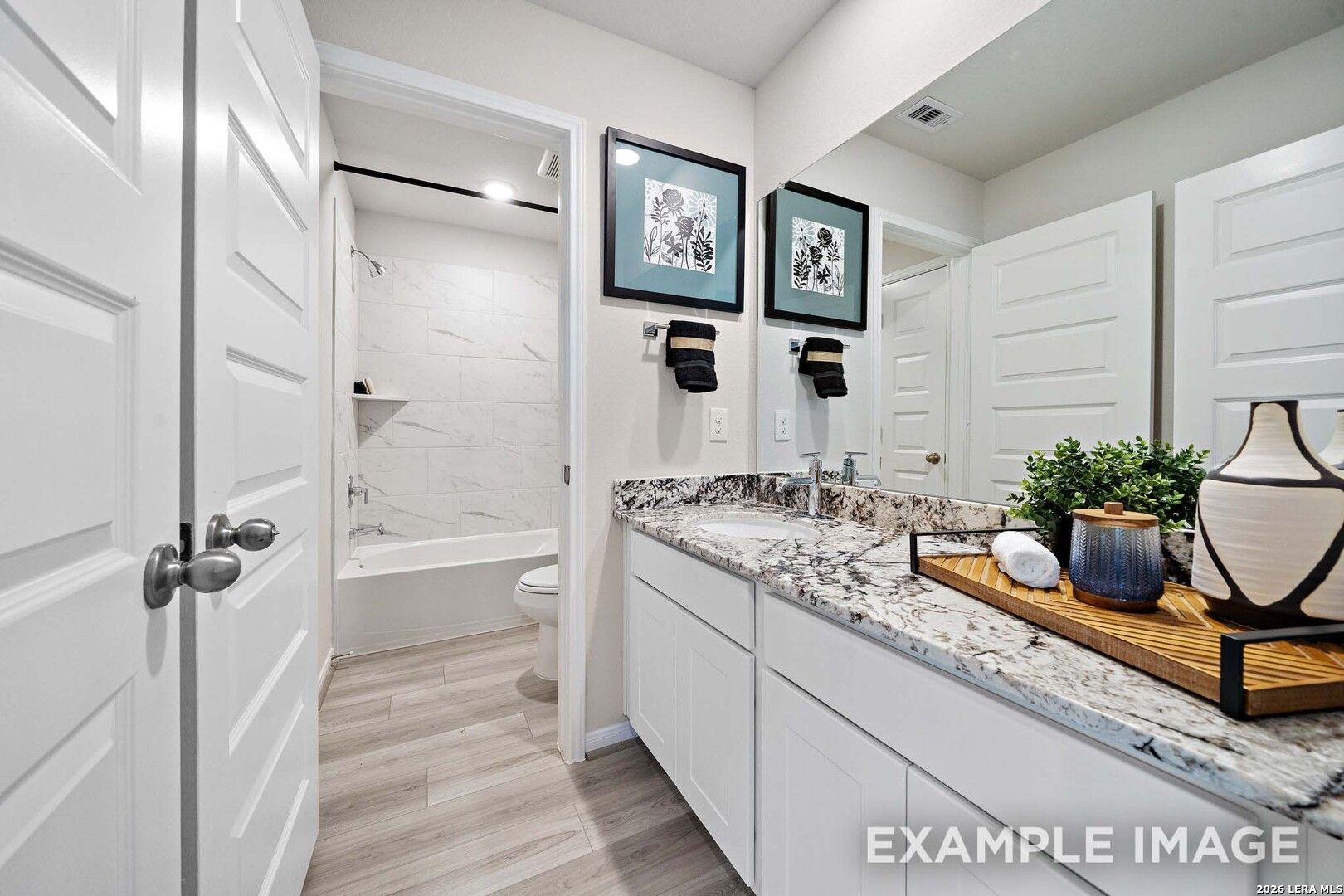 Modern bathroom with granite vanity and tub-shower combo in The San Marcos F floor plan at Rayburn Valley, San Antonio.