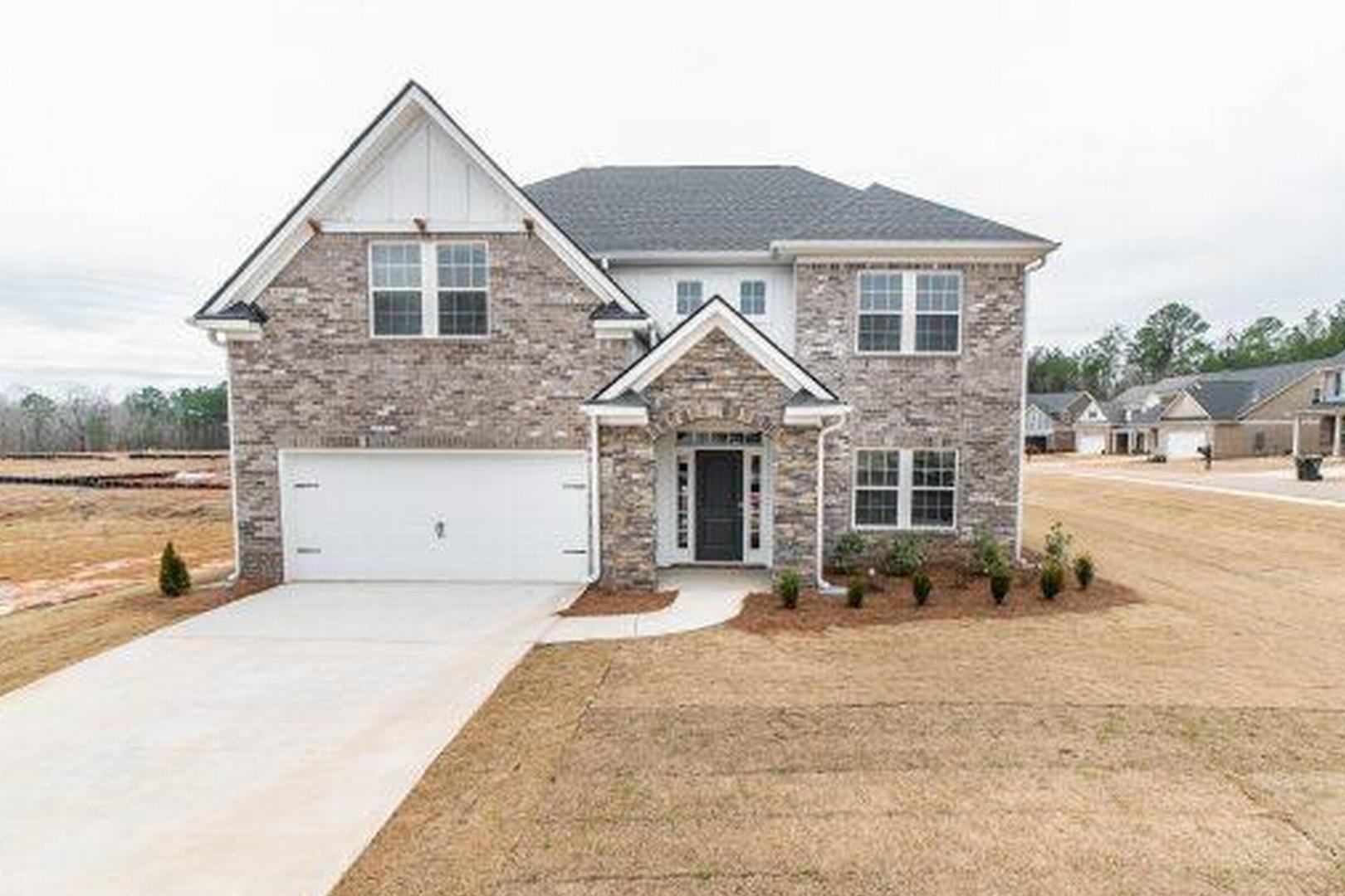 Modern brick Craftsman home at Cape Reserve Donahue Ridge in Auburn Alabama with covered porch, two-car garage, and landscaped yard